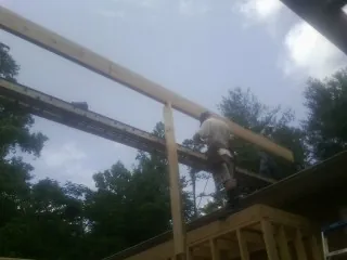 Carpenter setting a ridge beam over a new addition frame — Ice Dam Removal by Roofing Brothers in Wheelwright