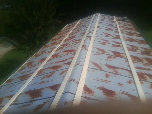 Rusted metal roof panels with new wood purlins before replacement — Storm Damage Roof Repair in Wheelwright by Roofing Brothers